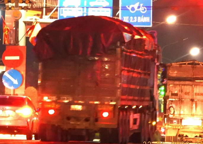 Tối 23/5, xe tải nặng chở hàng vượt chiều cao, có dấu hiệu quá tải lưu thông trên Quốc lộ 14, đoạn qua trung tâm TP Đồng Xoài. Ảnh: Lâm Thiện.
